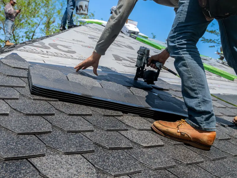 Roof repair in Miami: roofer fastening shingles