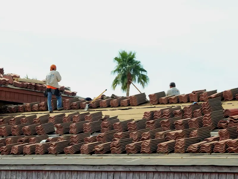 Roofing company in Miami working on a barrel tile roof