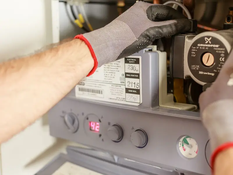 Water heater repair in Miami: hands adjusting heater controls
